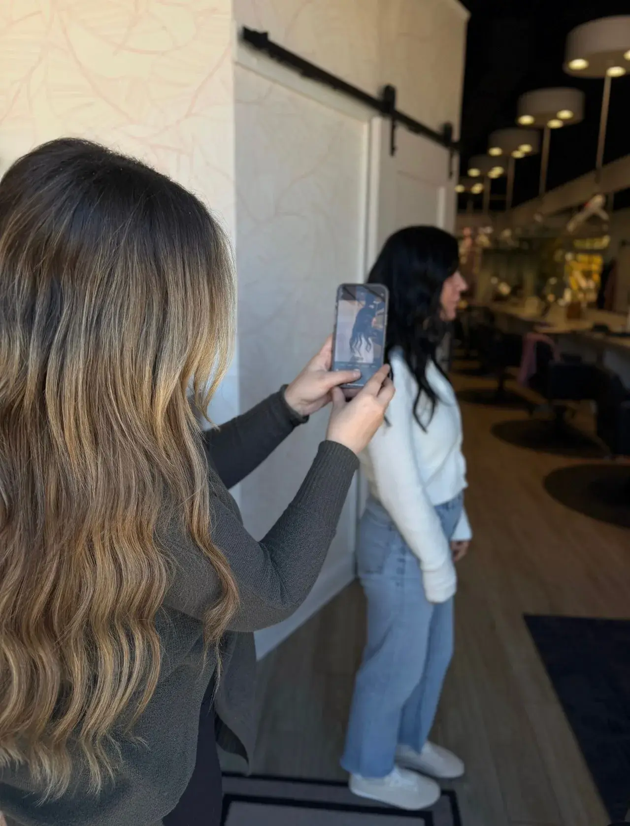 A stylist photographing a client's hair for a baseline